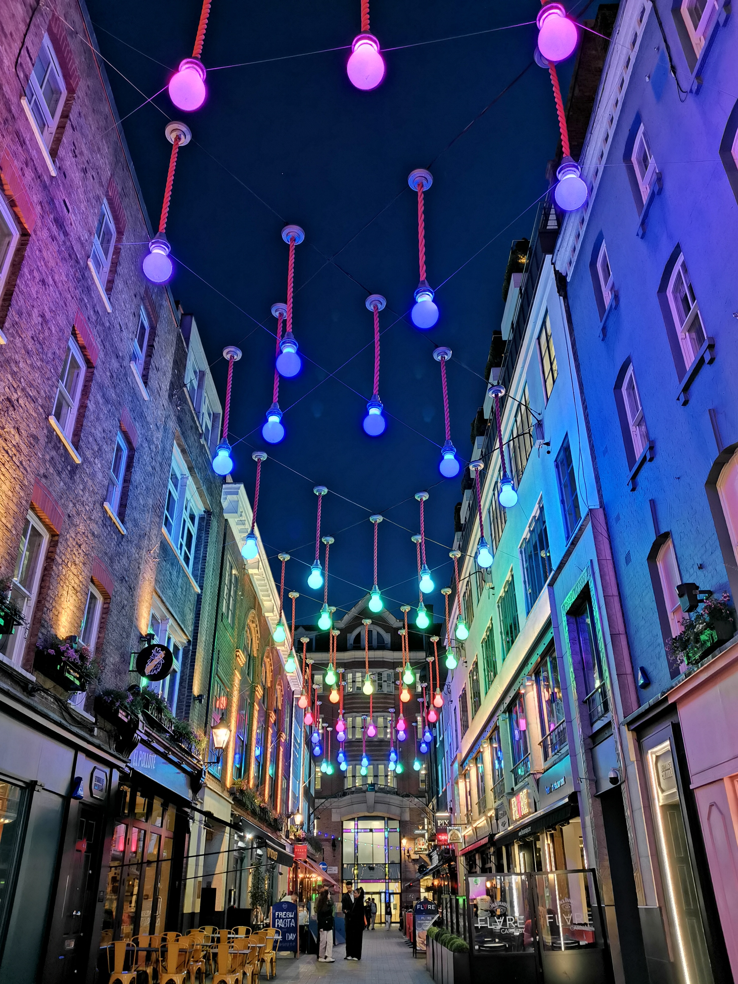 Carnaby: evening street decorated with lights and neon